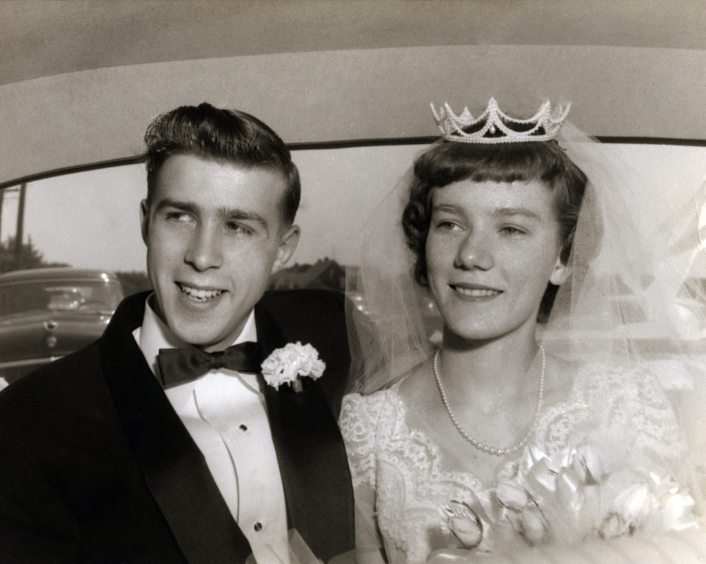 Black and White vintage bride and groom in the back of a car