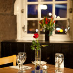 Close up of table, with red rose table decoration, in the Brasserie at Mercure Perth Hotel